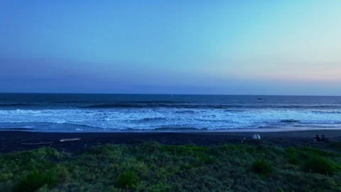 Twilight waves breaking along quiet dark beach Stock Footage 335440635