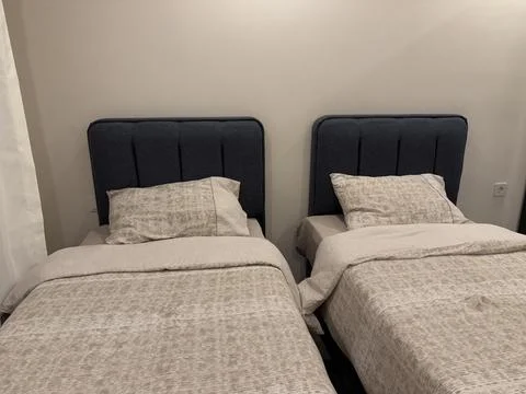 Twin beds with gray bedding in a simple bedroom interior background Stock Photos