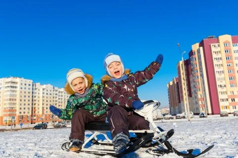 Twin brothers posing on snow scooter Stock Photos