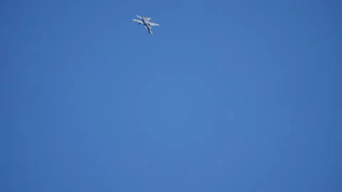Twin engine fighter jet banking steeply against clear blue sky Video stock 336264251