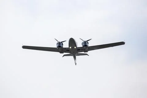 Twin-engine light aircraft flying in the sky Stock Photos