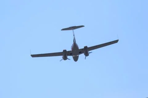 Twin-engine light aircraft flying in the sky Stock Photos