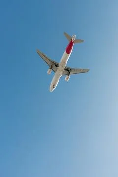 A twin-engine passenger plane descends before landing at an airport. Stock Photos