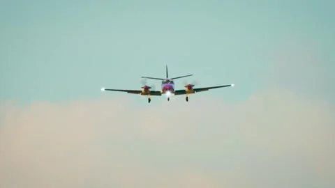 Twin engine turboprop airplane approaching runway with landing gear deployed Stock Footage 343757208