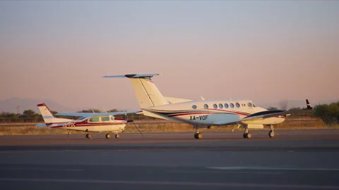 Twin engine turboprop and single engine aircraft parked on airport tarmac. Stock Footage 337907137