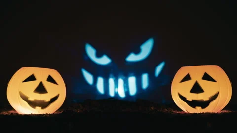 Twin jack-o-lanterns with evil smiling face projected Stock Footage 317623072