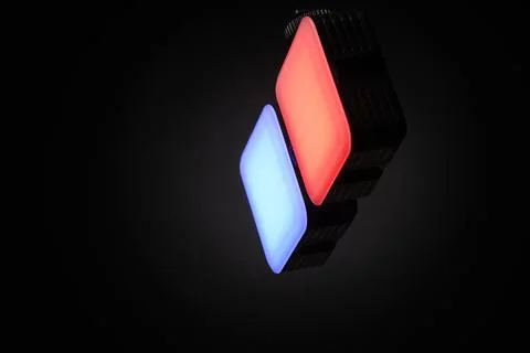 Twin LED panels emitting red and blue light isolated on black background Stock Photos