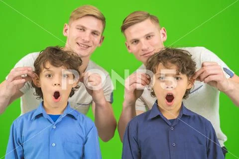 The twin play with a little brothers on the green background Stock Photos