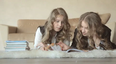 Twin sisters leafed through the book lying on the floor Stock-Footage 63122919