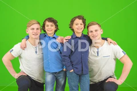 The twin stand with a little brothers on the green background Stock Photos