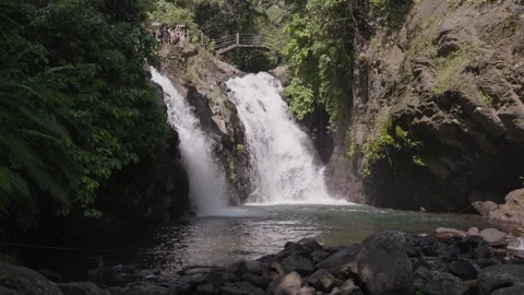 Twin streams of Kembar Waterfall cascade into rocky jungle pool Aling-Aling Bali Stock Footage 313612982