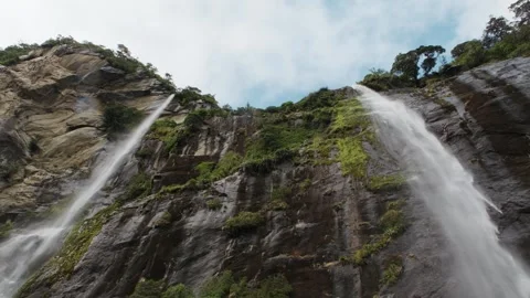 Twin waterfalls cascading down towering cliffs at Milford Sound, New Zealand Stock Footage 330950246
