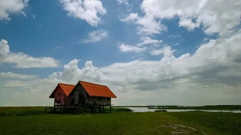Twin wood hut night clouds star moving time lapse Stock Footage 93767006