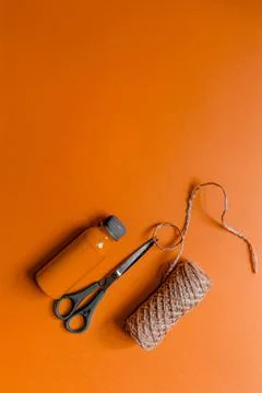 Twine, scissors and paint to create the decor lie on an orange background. Stock Photos
