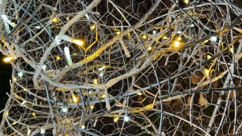 Twinkling garlands on a wire mesh create a festive mood.  動画素材 326134178