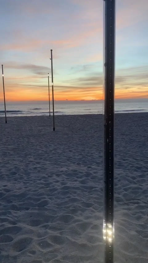 Twinkling light posts on sandy beach during sunset Stock Footage 136340370