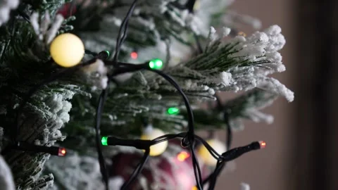 Twinkling light string on artificial Christmas tree with snow texture Stock Footage 259015831
