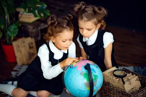 Twins examining globe Foto stock