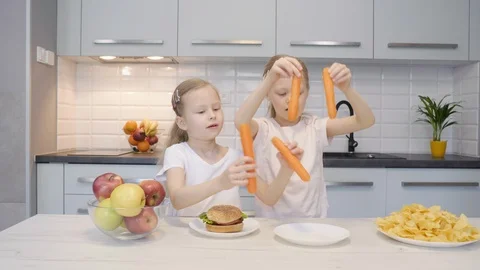 Twins having fun with carrots 스톡 동영상 107402422