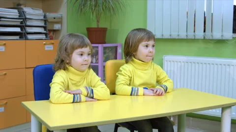 Twins siting at a table Stock Footage 64124145