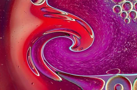 Twirling effect of bubbles on surface of water in red gradient background Stock Photos
