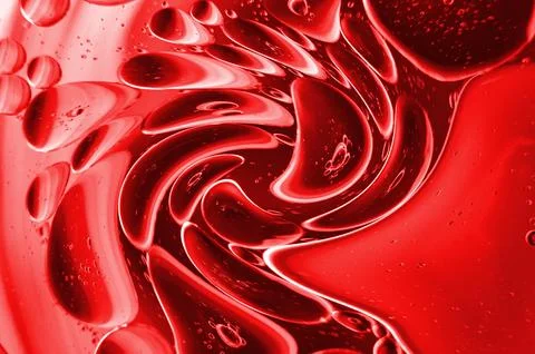 Twirling effect of bubbles on surface of water in dark red gradient backgroun Stock Photos