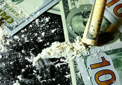Twisted banknote through which sniffing cocaine. Stock Photos