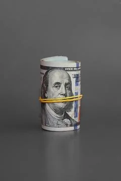 Twisted bundle 100 dollar bills, rolled bundle of hundred-dollar bills on a g Stock Photos