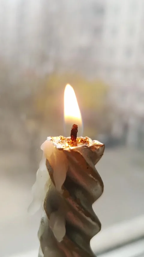 Twisted Candle Burning With Flickering Flame Against Blurry Window Stock Footage 325216223