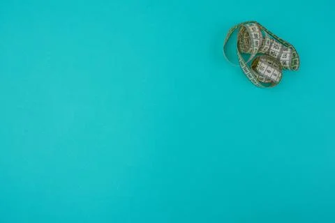 Twisted centimeter in the corner on a blue background Stock Photos