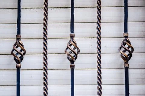 Twisted iron railing with a white shutter in background Stock Photos
