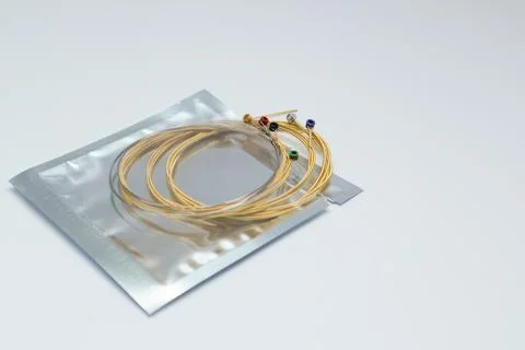 Twisted new guitar strings on white background. New acoustic guitar strings. Foto stock