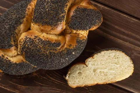 Twisted poppy seed bun on brown wood Stock Photos