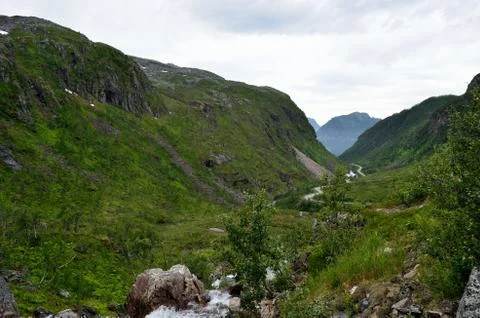 Twisted road through mountain valley with sea in distance Stock Photos