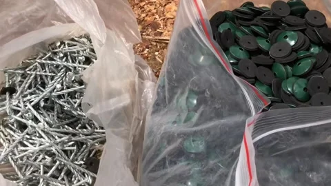 Twisted Roofing Nails,  self sealant and  Nail Caps in Bags at Construction Site Stock Footage 312485826