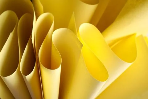 Twisted sheets of yellow paper as background Stock Photos