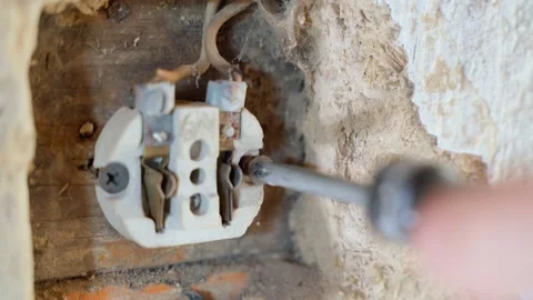 Twisting the ceramic body of a wall electrical outlet close-up. Repair of Stock Footage 205213674