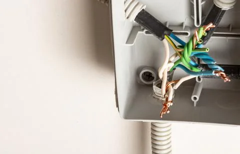 Twisting electrical wires in a junction box on the wall Stock Photos
