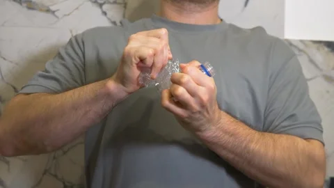 Twisting an empty plastic bottle by hand. Plastic waste disposal compression Stock Footage 340209121