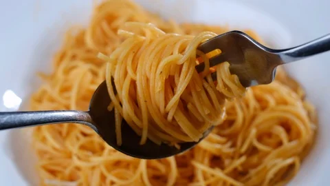 Twisting fork and spoon with Italian pasta capellini closeup Stock-Footage 121503471