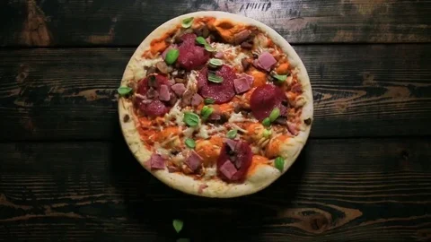 Twisting pizza on a wooden background Stock Footage 81398441