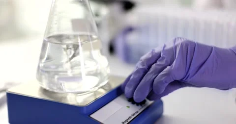 Twisting water in glass using a rotating water vortex machine in laboratory Stock Footage 232215922