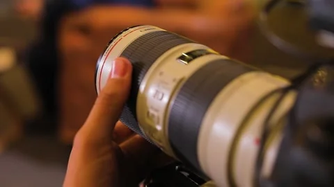 Twists the camera lens. Focus. Behind camera Stock Footage 155727616