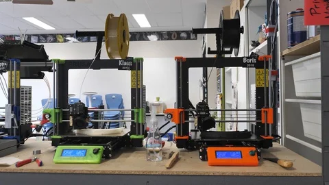 Two 3D Printers printing DIY COVID mask with plastic filament Stock Footage 127712930