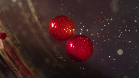 Two abstract red floating sparkling orbs morph together on a clear liquid bokeh Stock-Footage 118284729