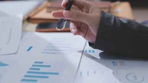 Two accountants examining financial documents using a calculator, taking no.. Stock Footage 336015712