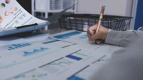 Two accountants examining financial documents using a calculator, taking no.. Stock Footage 336016040