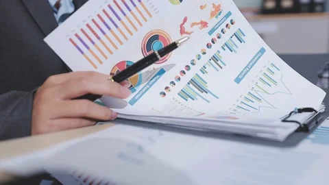 Two accountants examining financial documents using a calculator, taking no.. Stock Footage 336016231