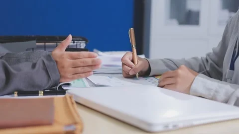 Two accountants examining financial documents using a calculator, taking no.. Stock Footage 336016697