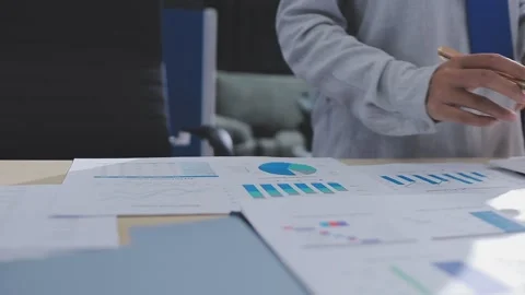 Two accountants examining financial documents using a calculator, taking no.. Stock Footage 336017132